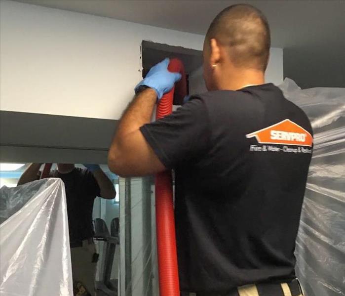 servpro employee cleaning air ducts