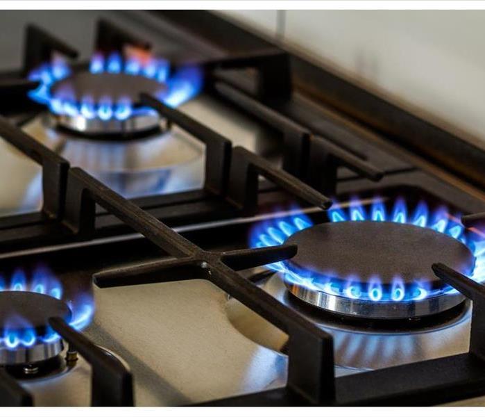 Natural gas burning on kitchen gas stove in the dark.