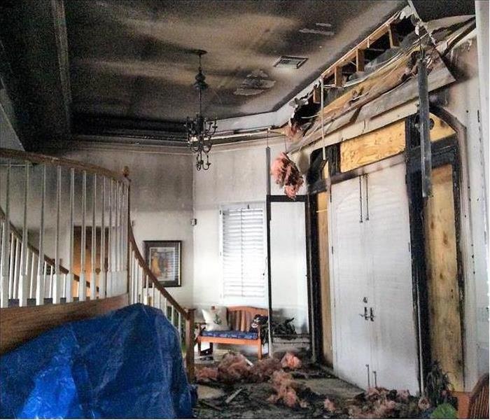 Inside of aa house damaged by fire, ceiling with soot, insulation from ceiling coming out